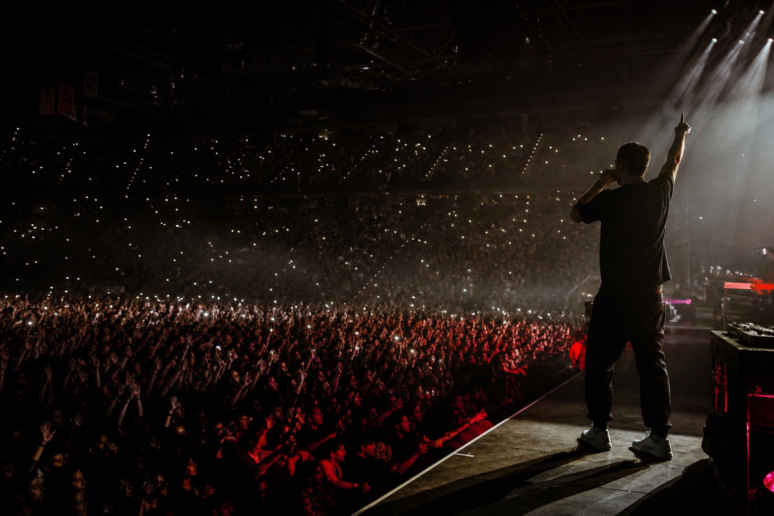 A touring artist performing for a packed arena crowd